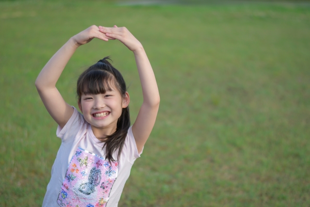 頭の上で丸をつくる子ども（女の子）